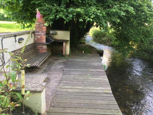 a wooden dock with a bench next to a river at Maesbury Riverside in Oswestry