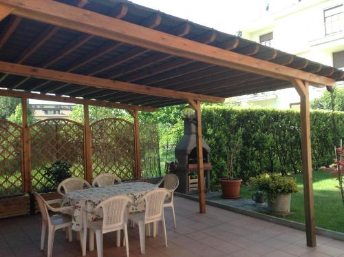 a wooden pergola with a table and chairs on a patio at Appartamento Sophia in Collegno