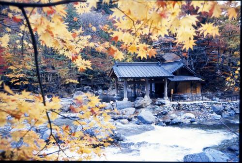 a small cabin in the woods with autumn leaves at Takaragawa Onsen Ousenkaku in Minakami