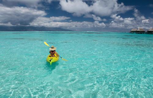 a woman in a yellow kayak in the ocean at Sofitel Kia Ora Moorea Beach Resort in Maharepa