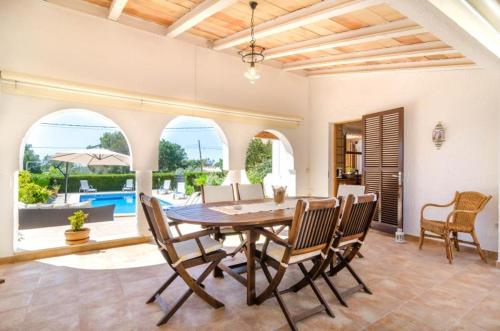 a dining room with a wooden table and chairs at Casa Garonda in Cala Pi
