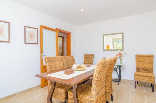 a dining room with a wooden table and chairs at Casa Garonda in Cala Pi