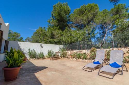 two chairs sitting on a patio next to a fence at Casa Garonda in Cala Pi
