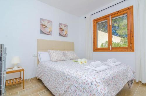 a bedroom with a bed with two towels on it at Casa Garonda in Cala Pi
