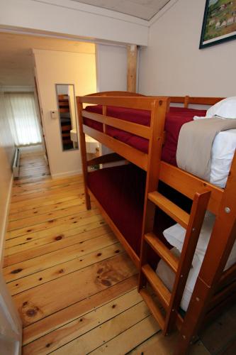 a bedroom with two bunk beds and a hallway at Trailside Inn in Killington