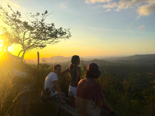 a group of people sitting on a ledge watching the sunset at Finca Carpe Diem Ecolodge in Minca