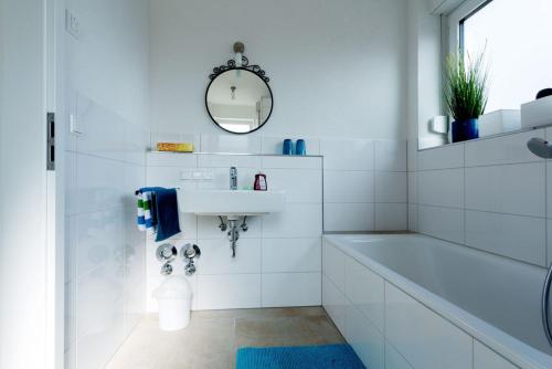 a white bathroom with a sink and a mirror at Ferienwohnungen Herzle in Bad Krozingen