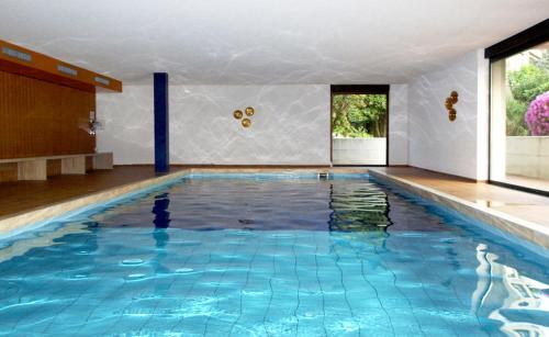 a large swimming pool with blue water in a room at Ferienwohnung Isabella in Ascona