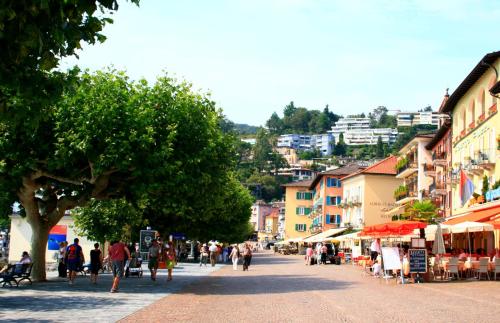 a street in a town with people walking down the street at Ferienwohnung Isabella in Ascona