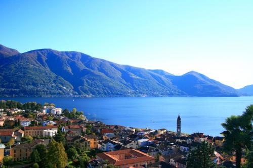 a town in front of a body of water with mountains at Ferienwohnung Isabella in Ascona