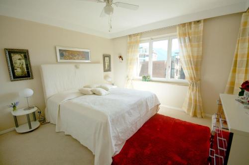a bedroom with a white bed and a window at Ferienwohnung Isabella in Ascona