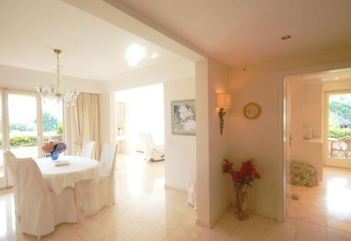 a dining room with a table and white chairs at Ferienwohnung Isabella in Ascona