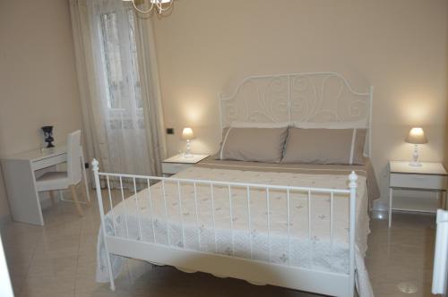 una camera con un letto bianco con due comodini di B&B La Colomba ad Altamura