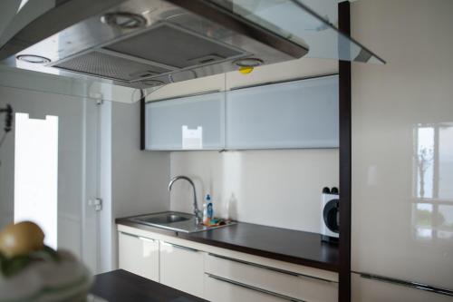 Una cocina con gabinetes blancos y un fregadero. en Fiesa-Piran beach house with free parking, en Piran