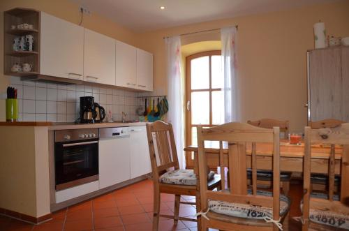 a kitchen with white cabinets and a table and chairs at Hofgut Wollin GmbH in Putgarten