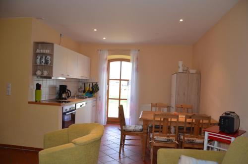 a kitchen and living room with a table and chairs at Hofgut Wollin GmbH in Putgarten