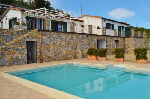 uma casa com piscina em frente a um edifício em Villa Nemo em Riva Ligure