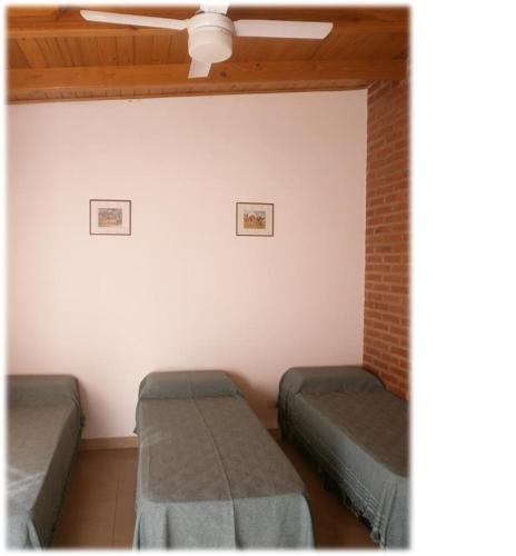 Habitación con 2 camas y ventilador de techo. en Hostal Centenario en El Carmen