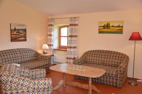 a living room with two couches and a table at Hofgut Wollin GmbH in Putgarten