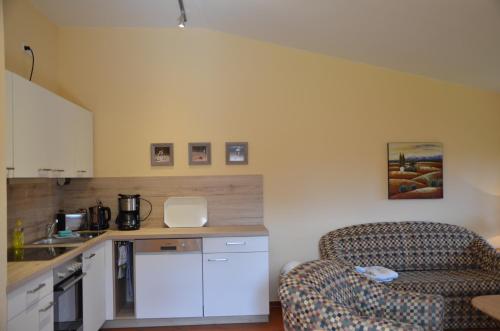 a living room with a couch and a kitchen at Hofgut Wollin GmbH in Putgarten