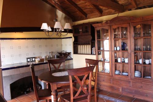 uma cozinha com uma mesa e cadeiras e uma lareira em Casa Rural el Riachuelo em Garafía