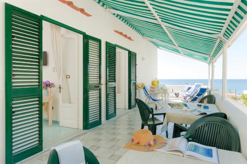 a patio with a table and chairs and the ocean at Appartamenti Baia di Citara in Ischia