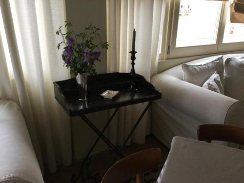 a table with a vase of flowers on it next to a couch at Hotel Karthea in Korissia