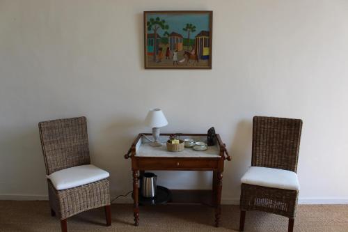 two chairs sitting next to a table with a lamp at L'Ancien Couvent Cahuzac in Cahuzac