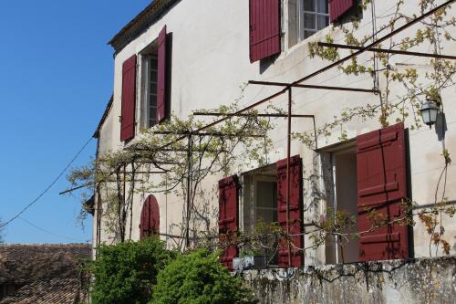 an old white building with red shuttered windows at L'Ancien Couvent Cahuzac in Cahuzac
