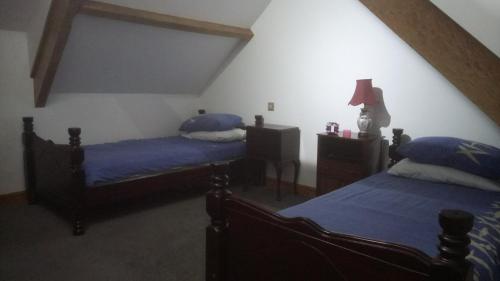 a bedroom with two beds and a lamp in it at The Old Swan in Cold Ashton