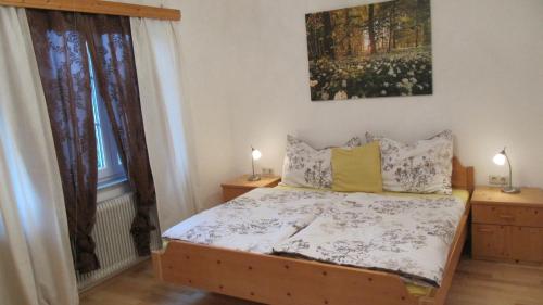 a bedroom with a bed with two windows and two lamps at Wohnung am See in Steinbach am Attersee