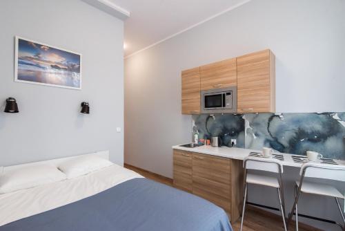 um quarto com uma cama e uma cozinha com um micro-ondas em Sopot Host Patio em Sopot