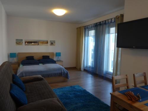 a bedroom with a bed and a flat screen tv at Apartament Aquamarina in Świnoujście