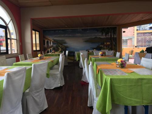 a dining room with green tables and white chairs at Isabela Hotel Suite in La Paz