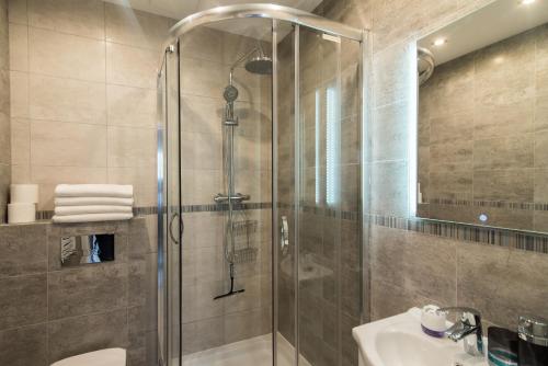 uma casa de banho com um chuveiro e um lavatório. em Sopot Host Patio em Sopot