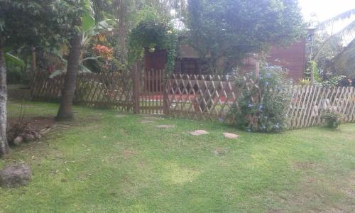 a wooden fence in a yard next to a house at Les Fougères in Baie-Mahault