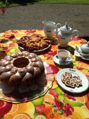 a table topped with cakes and teapots and cookies at Hotel Bergblick in Pomerode