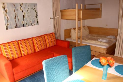 a living room with a couch and a table and a bunk bed at Apartments at Berghaus Glockner in Heiligenblut