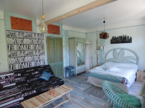 a bedroom with a bed and a bench and a table at Beau Site Guimauve et Vieilles Dentelles in Royères-Saint-Léonard