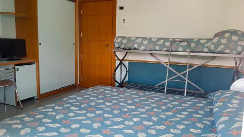 a small bedroom with a bunk bed and a desk at Hotel Gaby in Rimini