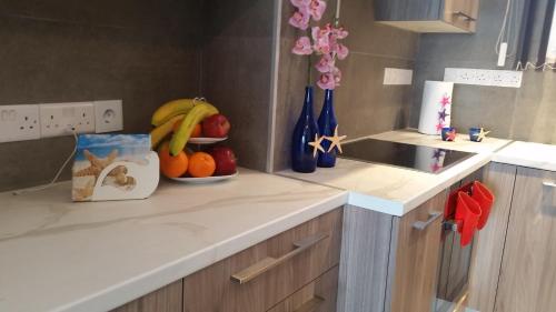a kitchen with a bowl of fruit on a counter at Periyiali Beach Sunset Suite A7 in Pervolia