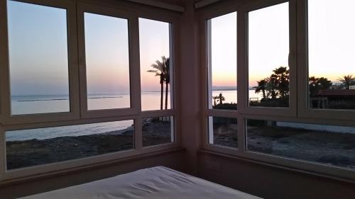 a bedroom with windows looking out at the beach at Periyiali Beach Sunset Suite A7 in Pervolia