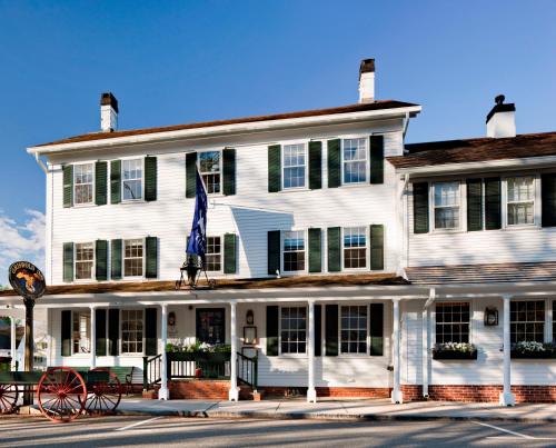 a large white building with a flag in front of it at The Griswold Inn in Essex
