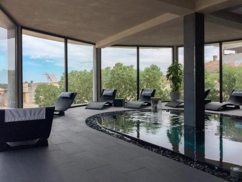 a pool in a building with chairs around it at Casa Font i Roig in Maria de la Salut