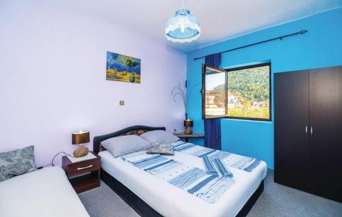 a bedroom with a large bed and a blue wall at Holiday Home Paul in Blace