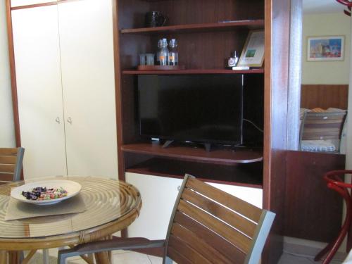 a dining room with a table and a television at Apartment Petrović in Korčula