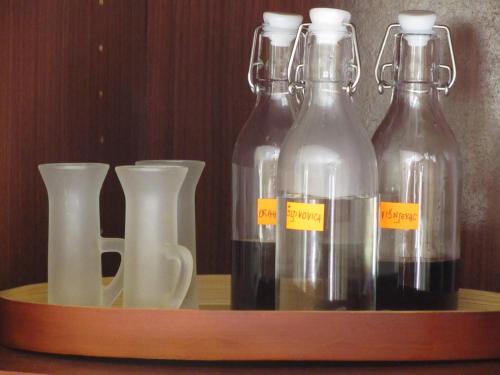 four glass bottles and vases on a wooden shelf at Apartment Petrović in Korčula