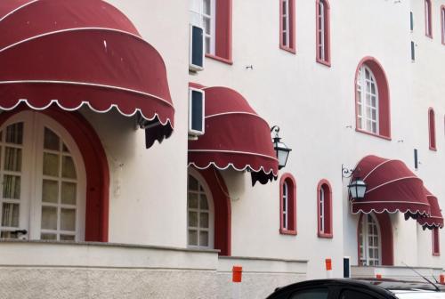 a building with red awnings on the side of it at Hotel Pousada do Arcanjo in Ouro Preto