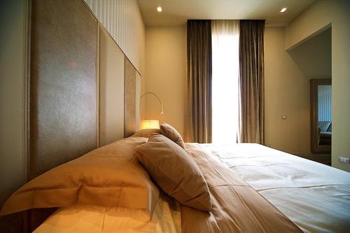 a large bed in a room with a window at Vittoriano Luxury Suites in Rome