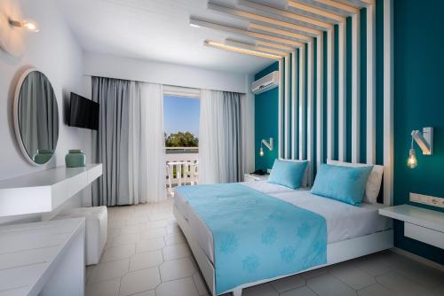 a blue bedroom with a bed and a mirror at Gaia in Style - Adults Only in Tigaki